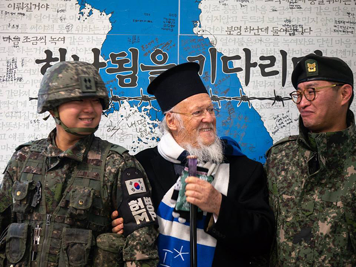  
Ecumenical Patriarch Bartholomew on Dec. 8, 2018, poses in a PyeongChangWinter Olympics scarf with Korean soldiers at the Demilitarized Zone near Cheorwon-gun County, Gangwon-do Province. (Orthodox Metropolis of Korea) 
